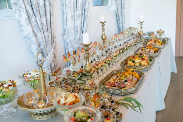 Lüks bir açık büfe, aperatifler ve yemekler geniş bir seçim, şık bir yemek deneyimi için süslü servis tepsileri düzenlenmiş.