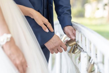 Romantik bir an. Yeni evli bir çift, aşklarını simgeleyen asma kilidi köprü korkuluklarında güvence altına alıyor. Bağlılıklarını ve birlikteliklerini ifade eden bir gelenek..