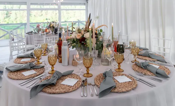 Çok güzel dekore edilmiş düğün masası. Mumlar, çiçekler, süslü bardaklar ve gümüş takımlar zarif bir atmosferde, renklendirme stili, sofistike ve detaylara dikkat..