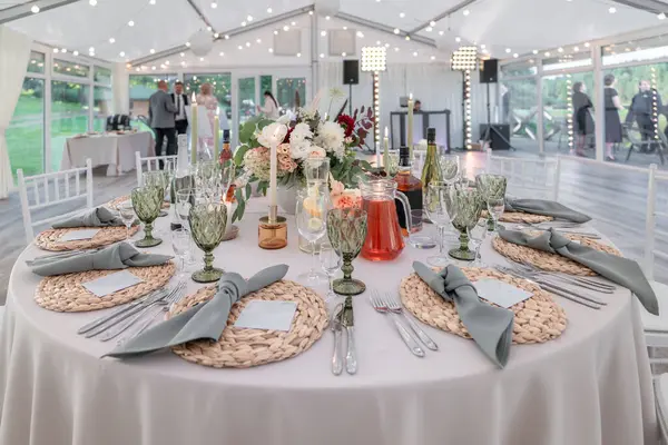 Çok güzel dekore edilmiş düğün masası. Mumlar, çiçekler, süslü bardaklar ve gümüş takımlar zarif bir atmosferde, renklendirme stili, sofistike ve detaylara dikkat..