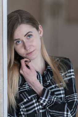 Tarz sahibi, siyah beyaz kareli gömlekli, kendine güvenen bir kadın.