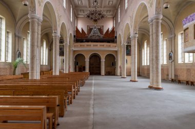 Sıcak ve davetkar kilise iç tasarımı zarif kemerler, ahşap koltuklar ve parlak yansıtıcı döşemeler dingin ve ruhani atmosferi yükseltiyor.