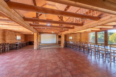 Döşeme döşemesi, ahşap kirişleri ve geniş pencereleri olan uçsuz bucaksız ahşap bir iç mekan. Toplantılar için mükemmel bir ortam, doğal ışık ve hoş ahşap mobilya düzenlemeleri..