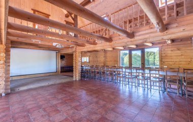 Döşeme döşemesi, ahşap kirişleri ve geniş pencereleri olan uçsuz bucaksız ahşap bir iç mekan. Toplantılar için mükemmel bir ortam, doğal ışık ve hoş ahşap mobilya düzenlemeleri..
