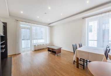 Ahşap döşemeleri, sade mobilyaları, doğal ışık sağlayan perdelerle kaplı pencereleri olan parlak, modern bir daire. Gösterişli yaşam alanları ve minimal ev tasarımları için ideal