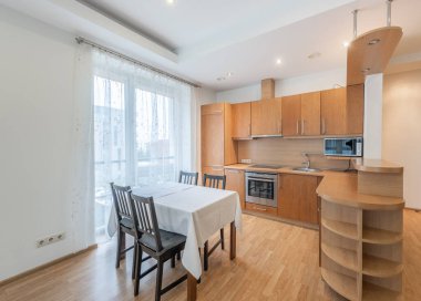 Geniş, çağdaş bir açık mutfak ve yemek alanı ahşap dekor temalı ve geniş pencereli davetkar ve rahat bir atmosfer yaratıyor..