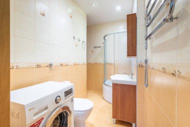 Duş kabini, fonksiyonel çamaşır makinesi ve fayanslı yüzeyli kompakt bir tasarımı olan modern banyo, küçük alanları optimize etmek ve çağdaş bir estetiği korumak için mükemmel..