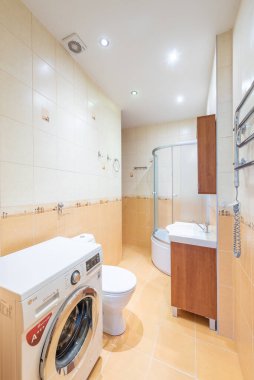 Duş kabini, fonksiyonel çamaşır makinesi ve fayanslı yüzeyli kompakt bir tasarımı olan modern banyo, küçük alanları optimize etmek ve çağdaş bir estetiği korumak için mükemmel..