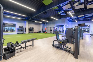 Spacious and modern gym facility featuring workout equipment, functional training area, and indoor training amenities, well-lit and designed for fitness enthusiasts seeking