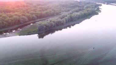 Güneşin doğuşunda Dnipro Nehri 'nde yelken açan bir balıkçının üst görüntüsü. Yüksek kalite 4k video