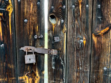 Locked in time: capturing the nostalgia of an old wooden woor with an aged lock. High quality photo