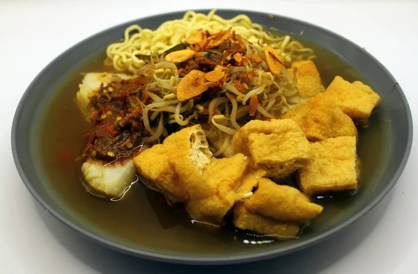 asian food,noodle soup with tofu in black bowl.