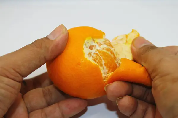 Portakalları elle soyar, portakalları kabuğu soyulur.