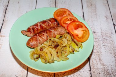 Soğanlı bir tavada pişirilmiş sosis..