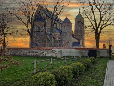 Historic buildings of the church and village in Tum, Poland. clipart
