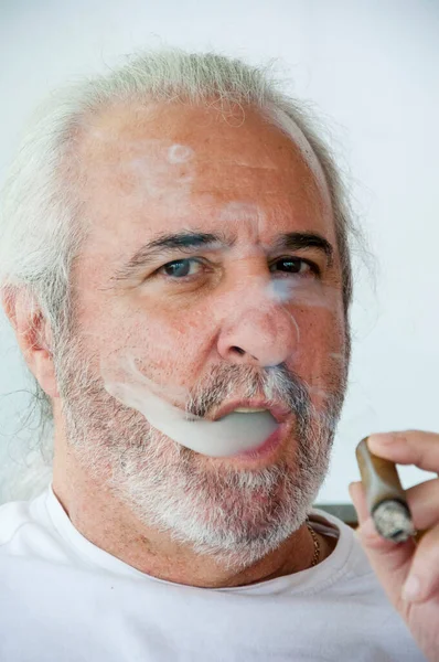 一个西班牙老人在烤一支古巴雪茄 古巴雪茄吸烟他的恐慌老头 退休生活方式 他惊慌失措的老爸抽着古巴雪茄 西班牙裔老人在享用古巴雪茄 在风格上的放松 — 图库照片