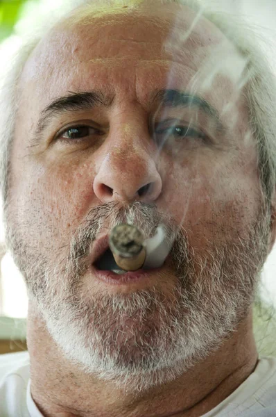 吸烟他的恐慌老头 在朋友的陪伴下他惊慌失措的老爸抽着古巴雪茄 西班牙裔老人在享用古巴雪茄 一个西班牙老人在烤一支古巴雪茄 古巴雪茄 — 图库照片