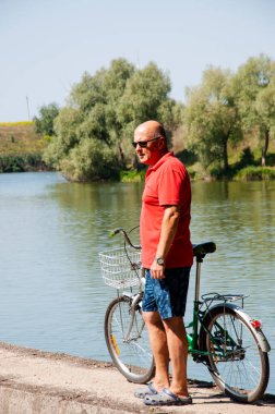 Yazın bisikletli bir adam. Dışarıda bisikleti olan bir bisikletçi. Yaz etkinliği eğlencesi ve aktif yaşam tarzı. Hafta sonu seyahati ve macera. İnsanlarla eğlence ve eğlence. yeni hedef.