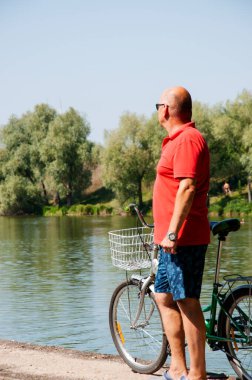İnsanlarla eğlence ve eğlence. Yazın bisikletli bir adam. Dışarıda bisikleti olan bir bisikletçi. Yaz etkinliği eğlencesi ve aktif yaşam tarzı. Hafta sonu seyahati ve macera. Boşluk afişini kopyala.