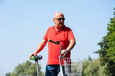 Yazın bisikletli bir adam. Dışarıda bisikleti olan bir bisikletçi. Yaz etkinliği eğlencesi ve aktif yaşam tarzı. Hafta sonu seyahati ve macera. İnsanlarla eğlence ve eğlence..