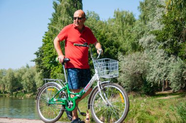 Yazın bisikletli bir adam. Dışarıda bisikleti olan bir bisikletçi. Yaz etkinliği eğlencesi ve aktif yaşam tarzı. Hafta sonu seyahati ve macera. İnsanlarla eğlence ve eğlence..