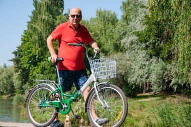 Yaz etkinliği eğlencesi ve aktif yaşam tarzı. Hafta sonu seyahati ve macera. İnsanlarla eğlence ve eğlence. Yazın bisikletli bir adam. Spor bisikleti olan bir bisikletçi..