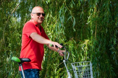 İnsanlarla eğlence ve eğlence. Yazın bisikletli bir adam. Dışarıda bisikleti olan bir bisikletçi. Yaz etkinliği eğlencesi ve aktif yaşam tarzı. Hafta sonu seyahati ve macera.