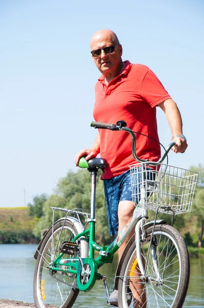 Dışarıda bisikleti olan bir bisikletçi. Yaz etkinliği eğlencesi ve aktif yaşam tarzı. Hafta sonu seyahati ve macera. İnsanlarla eğlence ve eğlence. Yazın bisikletli bir adam.