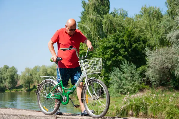 İnsanlarla eğlence ve eğlence. Yazın bisikletli bir adam. Dışarıda bisikleti olan bir bisikletçi. Yaz etkinliği eğlencesi ve aktif yaşam tarzı. Hafta sonu seyahati ve macera.