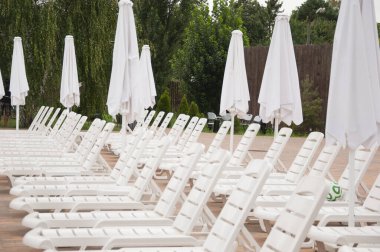 İskemleler dinlenme alanında. Yaz tatili. Yaz yaşam tarzı. Havuz başındaki açık hava tatil köyü. Havuz yatağı ve güneşlenme..