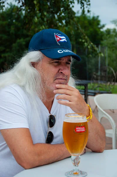 带啤酒的惊慌失措的人库班老人喝啤酒 老年人在户外用玻璃杯喝水 享受在酒吧里 喝啤酒 夏天的酒吧泡沫啤酒 — 图库照片