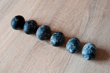 Paskalya yumurtası. Mutlu Paskalyalar. Paskalya bahar tatili. Tavşan avı selamı. Yumurta avı. Ahşap masada geleneksel boyalı yumurtalar. Minimalist tasarım. İlkbaharda yumurta avlamak. bahar doğu tatili.