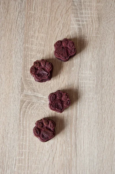 paw bakery cookie. pet cake. dog treat. pastry food for cat. appetizing pet muffins on wooden background. dog birthday. red velvet. paw shaped dog treat. homemade dog biscuit. Baked treats paw.