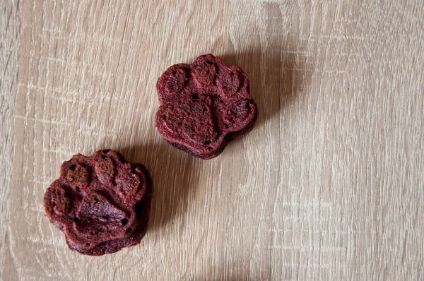 dog treat. pastry food for cat. appetizing dog muffins on wooden background. dog birthday. red velvet. paw shaped dog treat. homemade pet biscuit. paw bakery cookie. pet cake. copy space banner.