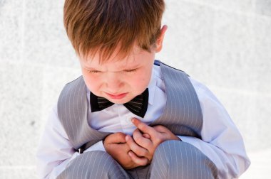 Smokin giymiş küçük bir çocuk. Erkek giyim bölümünde çocuk. Çocukluktaki beyefendiler için resmi kıyafet. Düğün için çocuk modası. Çocuklar için smokin ve smokin. Papyonlu çocuk zarafeti. Zarif smokinli küçük bir çocuk..