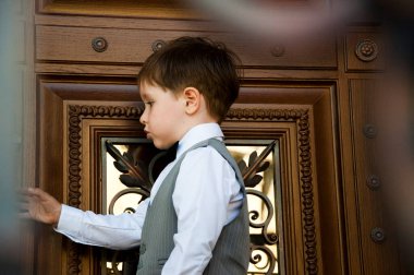 Çocuklar için smokin ve smokin. Papyonlu çocuk zarafeti. Zarif smokinli küçük bir çocuk. Smokin giymiş küçük bir çocuk. Erkek giyim bölümünde çocuk. Çocukluktaki beyefendiler için resmi kıyafet. Düğün için çocuk modası.