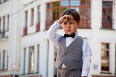Düğün için çocuk modası. Çocuklar için smokin ve smokin. Papyonlu çocuk zarafeti. Zarif smokinli küçük bir çocuk. Smokin giymiş küçük bir çocuk. Erkek giyim bölümünde çocuk. Çocukluktaki beyefendiler için resmi kıyafet.