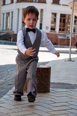 Zarif smokinli küçük bir çocuk. Smokin giymiş küçük bir çocuk. Erkek giyim bölümünde çocuk. Çocukluktaki beyefendiler için resmi kıyafet. Düğün için çocuk modası. Çocuklar için smokin ve smokin. Papyonlu çocuk zarafeti.