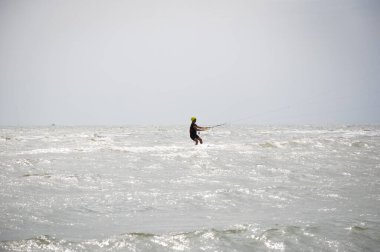 Henichesk, Ukrayna - 12 Temmuz 2021: Uçurtma. Yazın ekstrem spor ve su sporları. Yamaç paraşütü ve su kayağı. Adam uçurtma sürüyor. Deniz dalgaları üzerinde uçurtma. Serbest sörf. Yelkenli sporu.