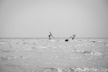 Henichesk, Ukrayna - 12 Temmuz 2021: Uçurtma. Yazın ekstrem spor ve su sporları. Yamaç paraşütü ve su kayağı. Adam uçurtma sürüyor. Deniz dalgaları üzerinde uçurtma. Serbest sörf. Yelkenli sporu.