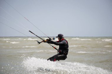 Henichesk, Ukrayna - 12 Temmuz 2021: Uçurtma. Yazın ekstrem spor ve su sporları. Yamaç paraşütü ve su kayağı. Adam uçurtma sürüyor. Deniz dalgaları üzerinde uçurtma. Serbest sörf. Yelkenli sporu.