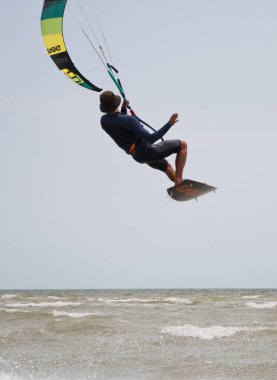 Henichesk, Ukrayna - 12 Temmuz 2021: Uçurtma sörfçüsüyle okyanus. Watersport adrenalin macera aktivitesi. Uçurtma. Uçurtma sörfü antrenmanı yapan aktif bir sporcu..