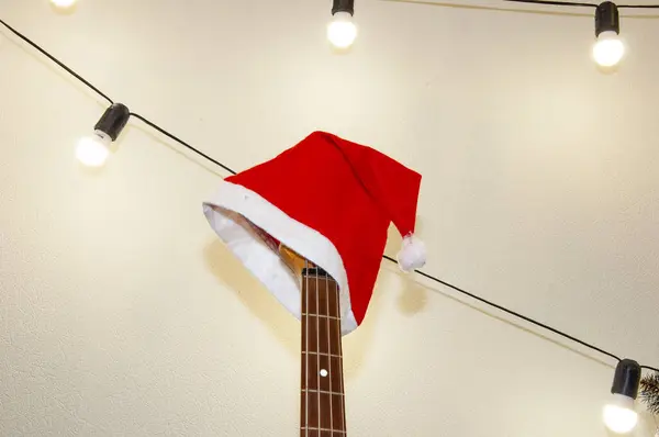 Happy Ney Year. Xmas holiday celebration. New Year eve. Santa Claus hat on guitar. December holiday with music playlist. Decorated Xmas electric guitar. Christmas music playlist. Merry Christmas.