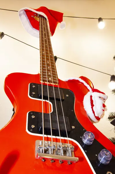 December holiday with music playlist. Decorated Xmas electric guitar. Christmas music playlist. Merry Christmas. Happy Ney Year. Xmas holiday celebration. New Year eve. Santa Claus hat on guitar.