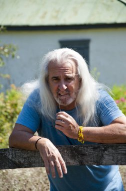 Hispanik karizmatik, sağlıklı, olgun, kır çiftliğinde ya da yazları kır çiftliğinde uzun kır saçlı yaşlı bir adamın emekliliği kutlu olsun..