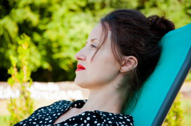 Kadınlar yaz güneşlenirken dışarıda dinlenirler. Yaz tatili. Havuz kenarında yaz zamanı. Latin bir kız parkta güneşlenir. Yazlık tatil beldesinde. Kadın rahatlama ve dinlenme.