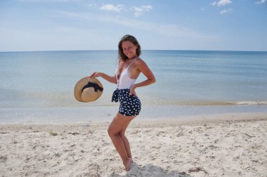 Plajda yaz tatilindeki bir kadın. Mayo ve hasır şapkalı kadınların yaz tatili. Deniz sahilindeki Retro kadın. Yaz plajında güneş yanığı. Retro kızın plaj tatili. Deniz yolculuğu merkezi. Bermuda.