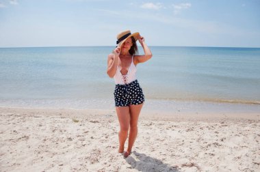 Plajda yaz tatilindeki bir kadın. Mayo ve hasır şapkalı kadınların yaz tatili. Deniz sahilindeki Retro kadın. Yaz plajında güneş yanığı. Retro kızın plaj tatili. Deniz yolculuğu merkezi. Filipinler.