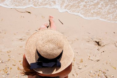 Yaz plajında güneş yanığı. Retro kızın plaj tatili. Deniz yolculuğu. Plajda yaz tatilindeki bir kadın. Hasır şapkalı bir kadının yaz tatili. Deniz kumsalındaki Retro kadın. Bahamalar.