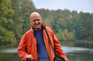 Havuzda sonbahar tarzı mutlu bir adam. Göl kenarında yetişkin bir adam. Parkta sonbahar adamı. Sonbahar sezonunda Central Park 'ta. Park 'ta son sınıf öğrencisi. Sonbahar açık havada. Mutlu sonbahar doğası.
